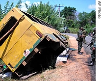 Soldiers patrol near a bus overturned by a a href=