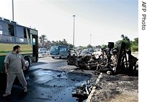 An Iraqi walks away from the site where a car Bomb and an a href=