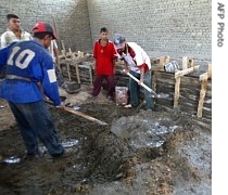 Construction workers mix cement at a power station under construction in the poor eastern neighborhood of Sadr city in Baghdad, 22 Aug 2005