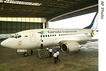 Workers inspect a Garuda Indonesia plane inside a hangar at Soekarno-Hatta airport in Jakarta, 12 Jun 2007 