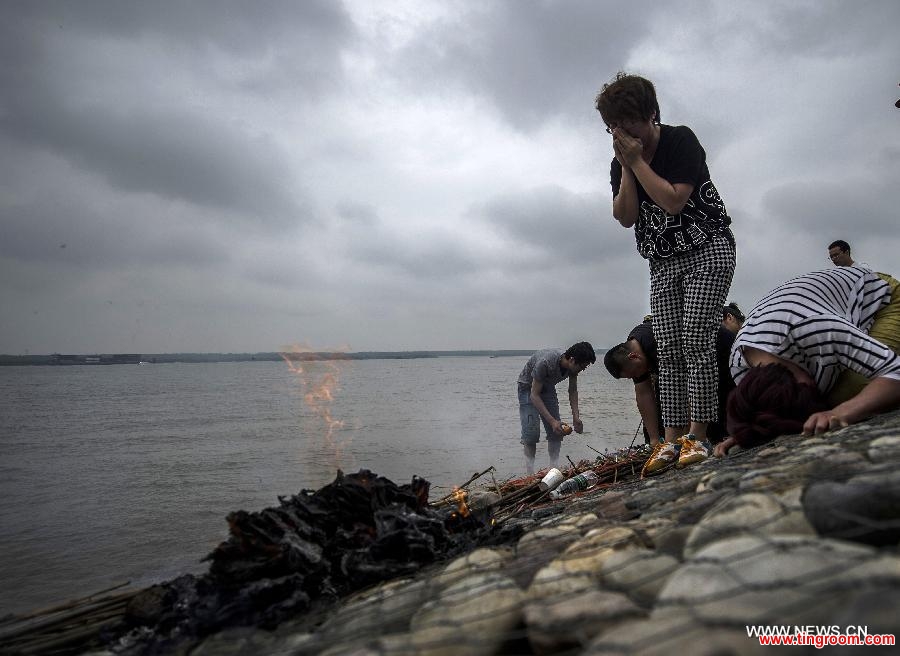 Relatives of the victims of the capsized ship Eastern Star mourn at the bank of the Jianli section of the Yangtze River, central China