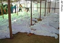 Covered bodies are laid out as Tutsi refugees from Congo, who survived a a href=