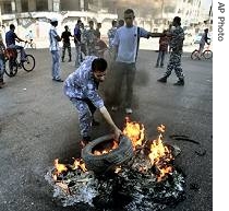 Palestinian police officer burns tires during a a href=