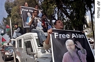 Palestinian journalists hold posters of BBC correspondent Alan Johnston, during a car a href=