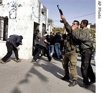 A Palestinian police officer fires into the air after he and others stormed the a href=