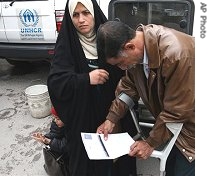 An Iraqi refugee and his wife view a href=