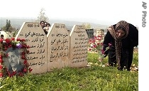 Kurdish woman places flowers at graves of her loved ones in Halabja, 16 a href=