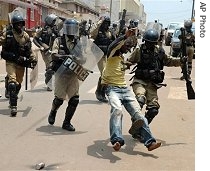 Ugandan riot police arrest a protestor as they a href=