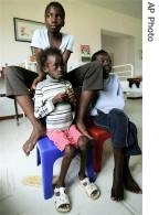 Lerato, 7, sitting left, and her friends Abigain, 11, right, and Koketso, 14, watch television while being treated in the medical clinic of the Sparrow Rainbow Village in Johannesburg (File photo)