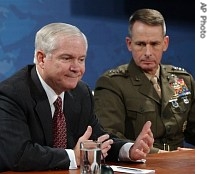 Defense Secretary Robert Gates, left, accompanied by a href=