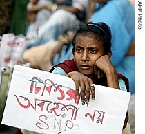 An Indian woman hold a poster saying 'Do not neglect the treatment' as she takes part in an HIV a href=