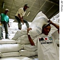 East Timorese workers carry sacks of rice at a WFP a href=