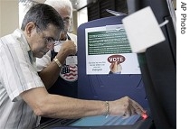 Jose DeLa Hoz, left, practices on a demo voting machine before casting his a href=