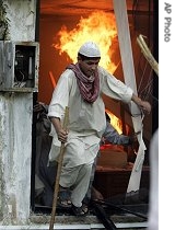 Pakistani students run out of a government office after setting on fire after a clash with police outside the Red a href=