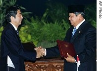 Japanese Prime Minister Shinzo Abe (l) and Indonesian President Susilo Bambang Yudhoyono shake hands after the signing ceremony of a a href=