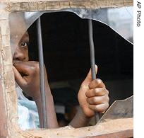 An unidentified girl looks from a broken window at the Just Children Foundation for a href=