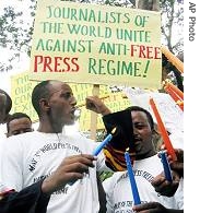 Ethiopian journalists hold placards and lighted candles as they shout slogans during a a href=