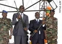 Ivorian President Laurent Gbagbo (2ndL) and PM Guillaume Soro (2ndR) pose with the rifles they were given, during a disarmament and a href=