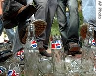 Students stamp on Pepsi bottles during a protest demanding the ban on sale of soft drinks in school and college cafeterias during a protest in Ahmadabad, India