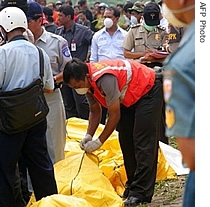 A police officer checks the bodies of victims that were killed in Garuda plane crash, in Yogyakarta, 07 a href=