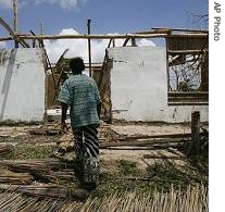 Simone Chivale, 30, walks towards a destroyed home, in the Mozambique a href=