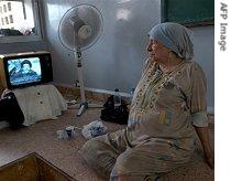 An elderly Lebanese woman watches Hezbollah leader Hassan Nasrallah say his group would a href=