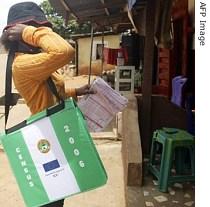 A census counters stops by a house in Asaba, Nigeria 