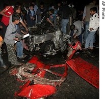 Palestinians check the damage of the destroyed car of Islamic Jihad a href=