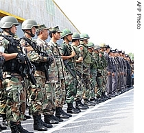 Thai soldiers and police officers stand as pay their respects to a colleague who was shot dead by a href=