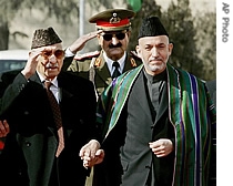 Former King of Afghanistan Zahir Shah, left is seen as Afghanistan President Hamid Karzai walks towards the a href=