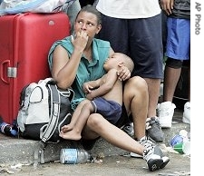 A woman and her child wait with hundreds of other flood a href=